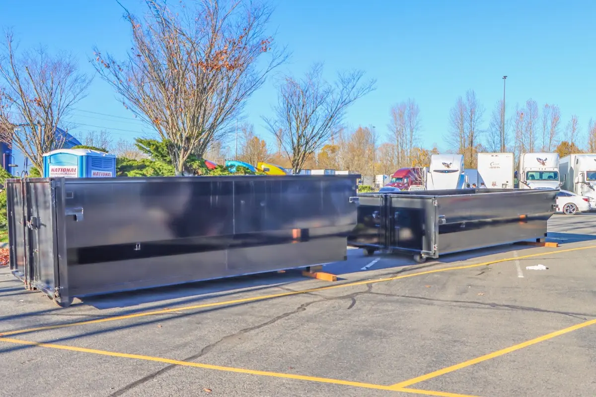 Professional dumpster rental service with roll-off container on residential driveway in Williamsburg